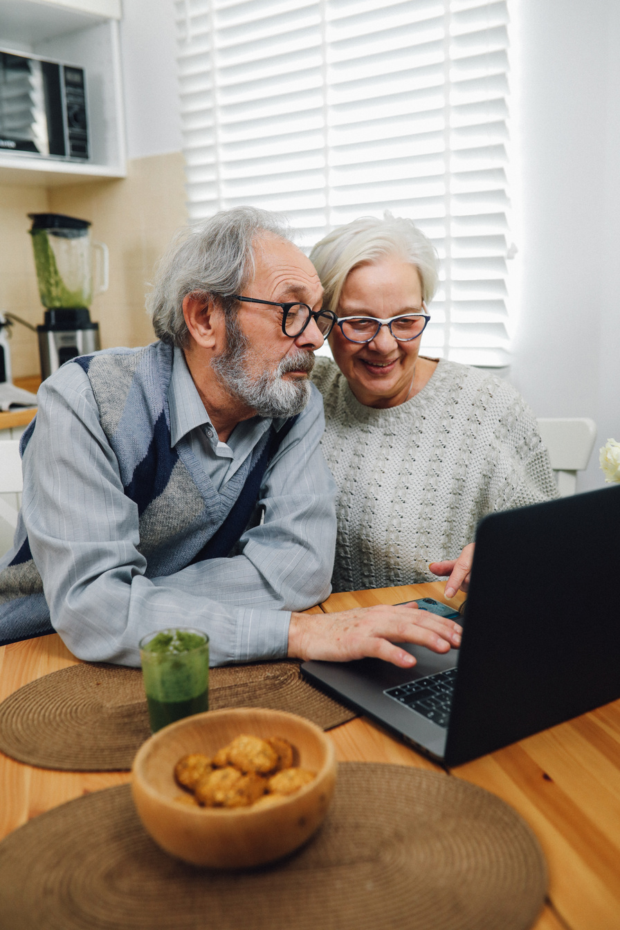 Happy Elderly Couple Using Laptop at Home